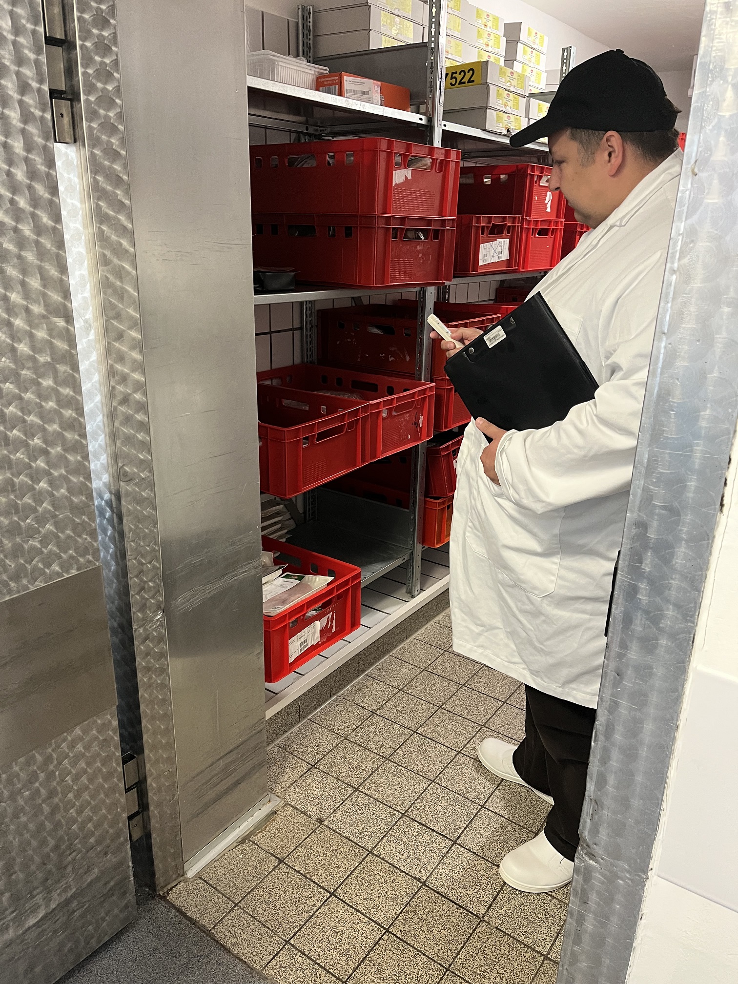 Antonio D’Angelo, Lebensmittelkontrolleur in Fortbildung beim Landkreis Gießen, überprüft die Temperatur der verpackten Wurst in einem der Kühlräume der UKGM-Küche. (Foto: Landkreis Gießen)