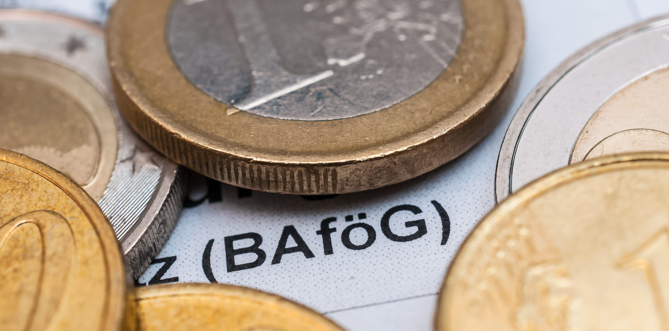 Euro-Münzen, die auf einem Papier liegen, auf dem in Klammer "BAföG" zu lesen ist.